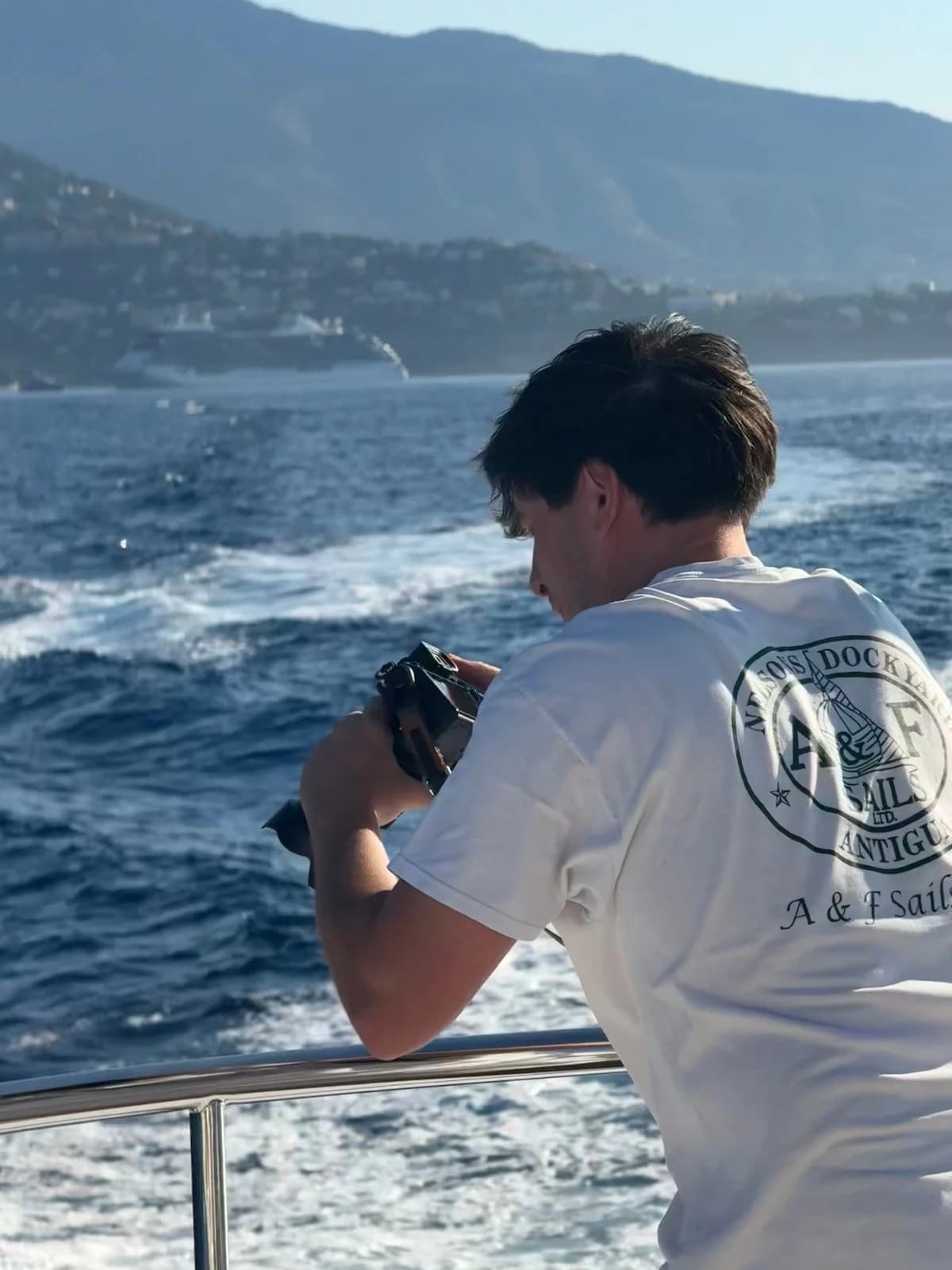 Man with a camera taking photos for yacht marketing