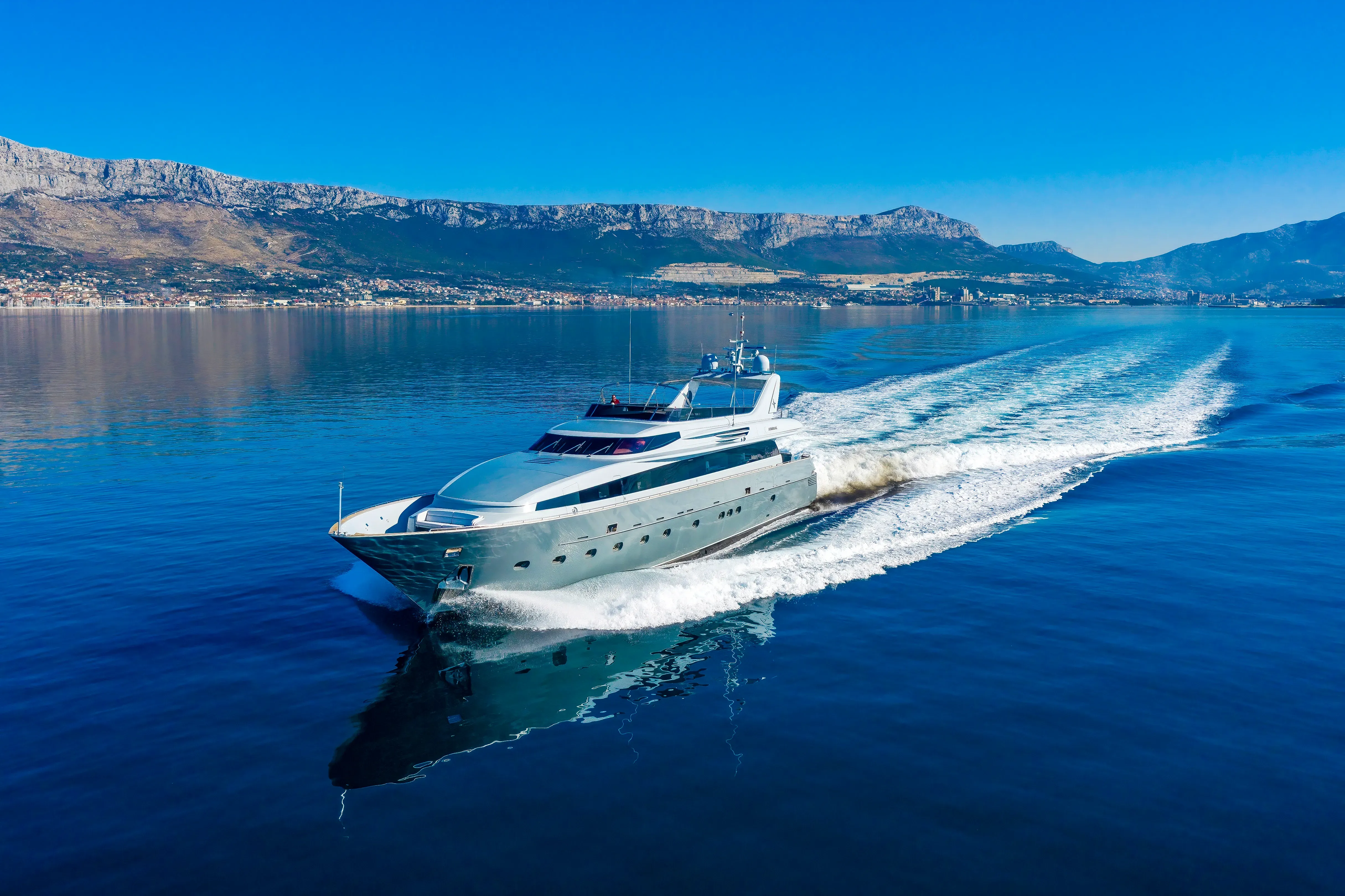 The luxury motor yacht ANAVI, a 36.1m Admiral, gracefully cruising in the vibrant blue waters of the French Riviera under a clear sky, showcasing its sleek profile and modern design.